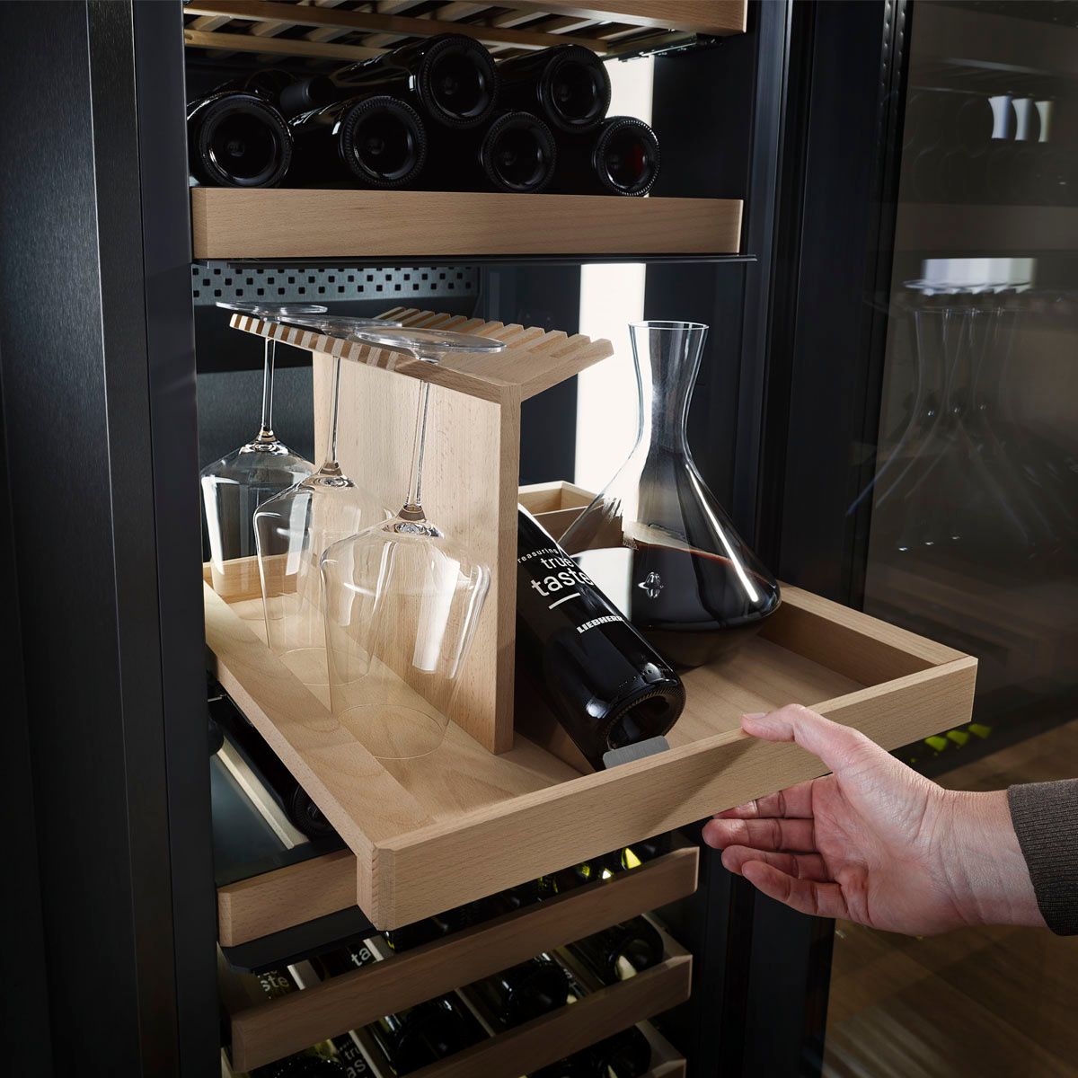 Sommelier εξετάζει φιάλη κρασιού μπροστά σε συντηρητή